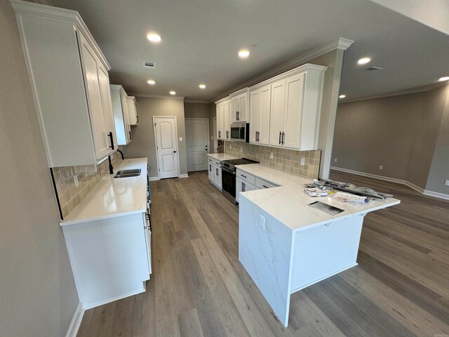 kitchen with tasteful backsplash, white cabinetry, sink, and stainless steel appliances