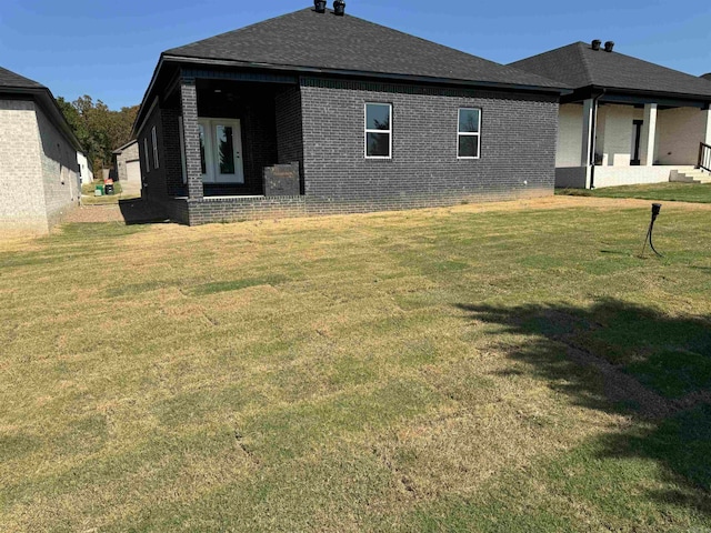 rear view of house featuring a yard