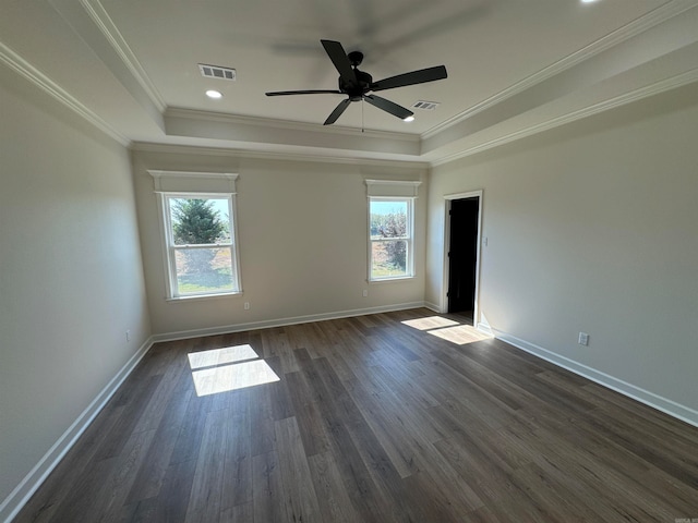 unfurnished room featuring ceiling fan, a raised ceiling, dark hardwood / wood-style floors, and ornamental molding