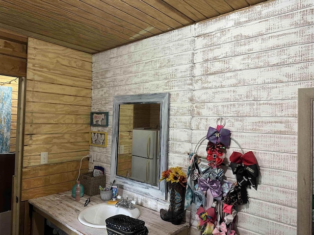 bathroom with wood walls, vanity, and wood ceiling