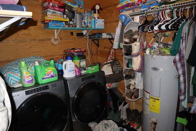 washroom with electric water heater, washer and clothes dryer, and wooden walls