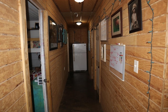 hallway featuring wood walls