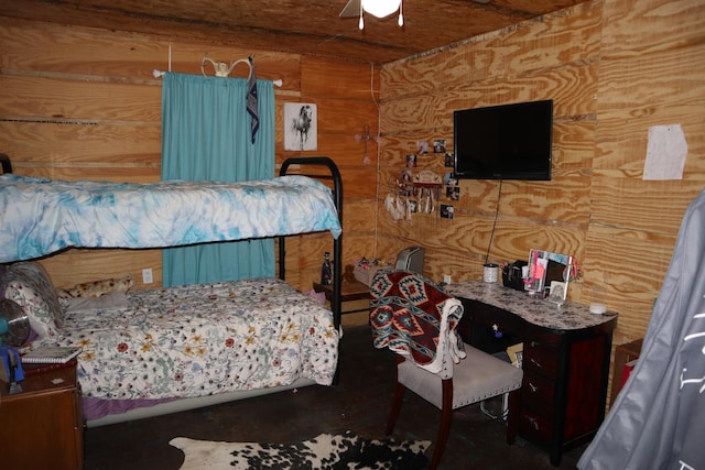 bedroom featuring ceiling fan and wooden walls