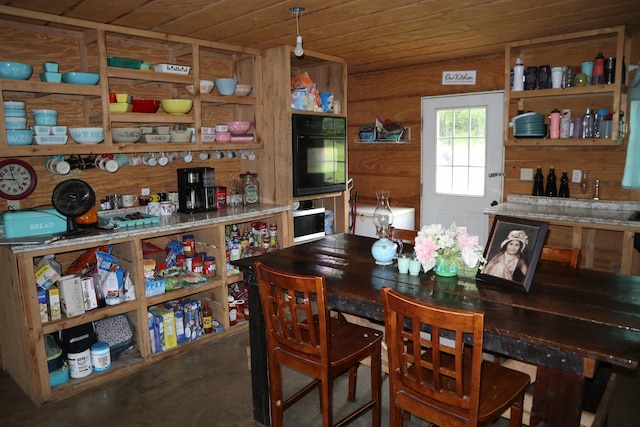 dining room featuring wooden ceiling and wooden walls