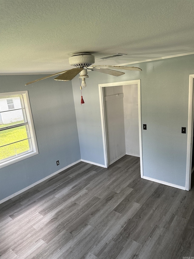 spare room featuring a textured ceiling and dark hardwood / wood-style floors