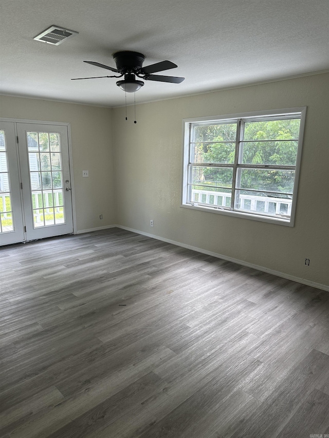 empty room featuring a textured ceiling, ceiling fan, and dark wood-type flooring