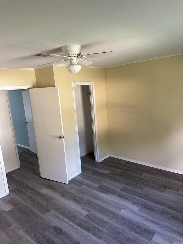 spare room featuring ornamental molding, ceiling fan, and dark wood-type flooring