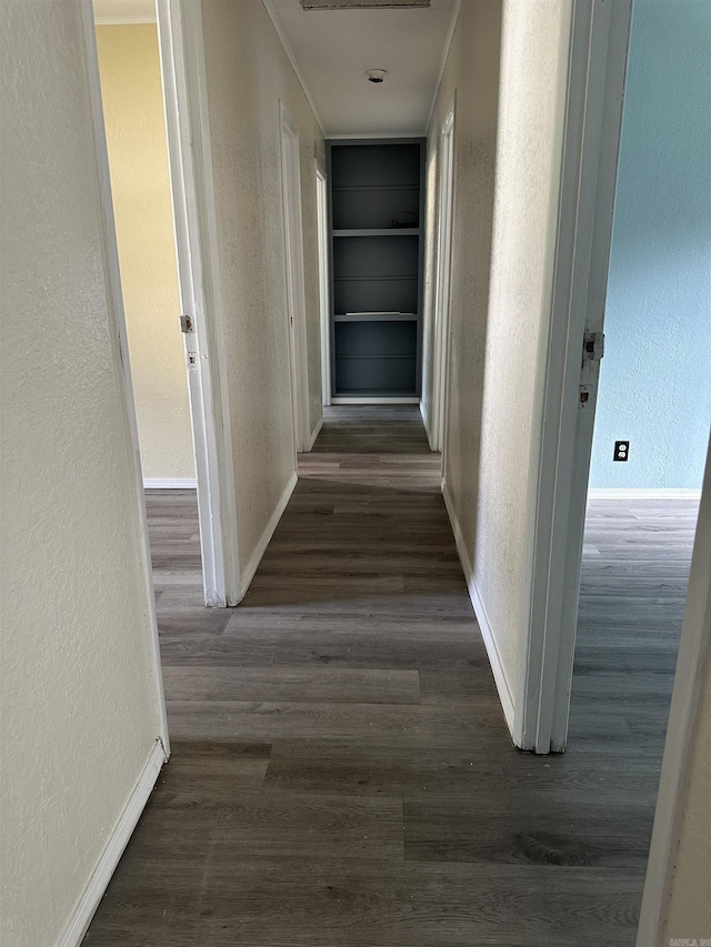 hall with built in features and dark wood-type flooring