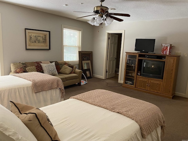 bedroom featuring ceiling fan, dark carpet, and a textured ceiling