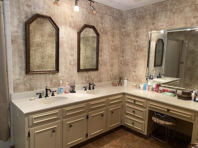 bathroom with tile patterned flooring, vanity, and a textured ceiling