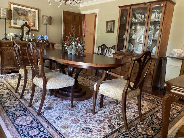 dining area with crown molding and a chandelier