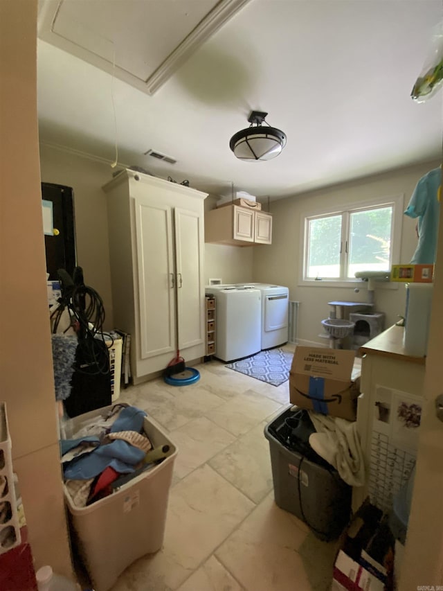 laundry room featuring washer and clothes dryer, light tile patterned flooring, cabinets, and ornamental molding