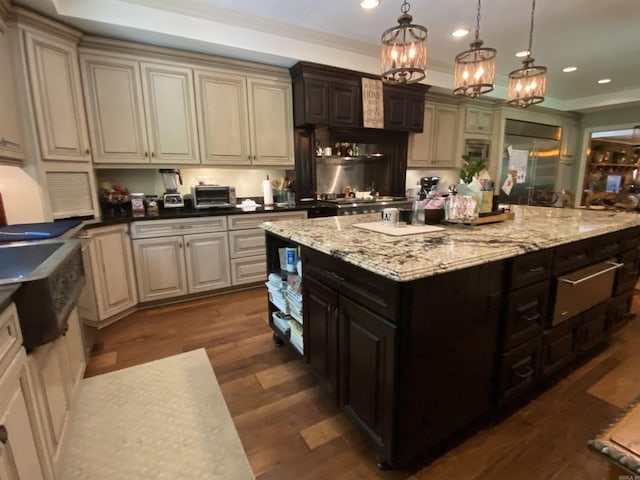 kitchen featuring dark brown cabinetry, hanging light fixtures, dark hardwood / wood-style flooring, cream cabinets, and a chandelier