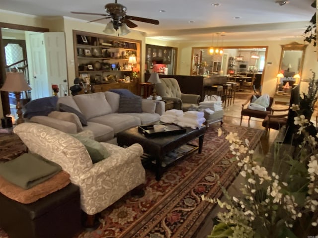 tiled living room with ceiling fan with notable chandelier