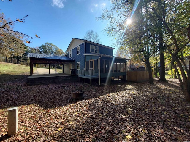 rear view of property featuring a gazebo and a sunroom