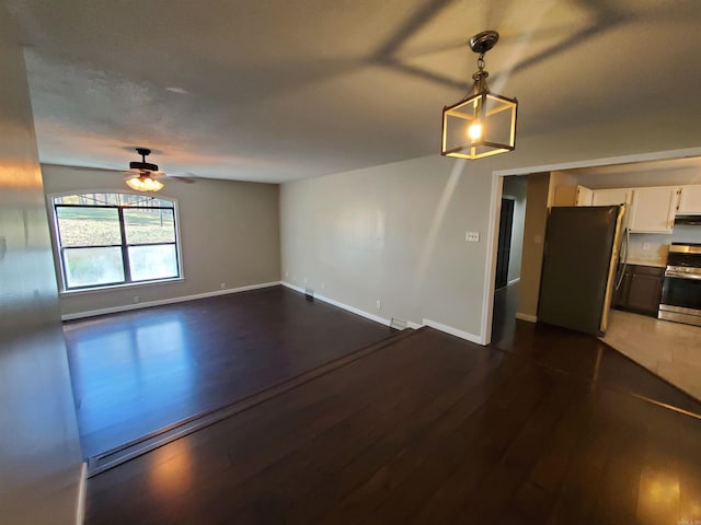 empty room featuring ceiling fan and dark wood-type flooring