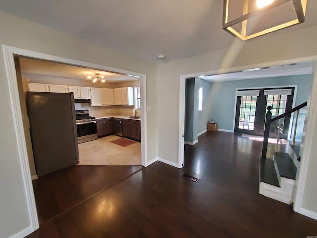 kitchen featuring white cabinetry, french doors, wood-type flooring, and appliances with stainless steel finishes