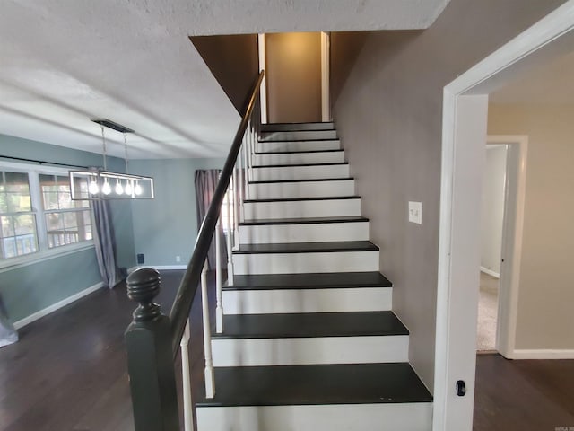 stairs featuring wood-type flooring and a textured ceiling