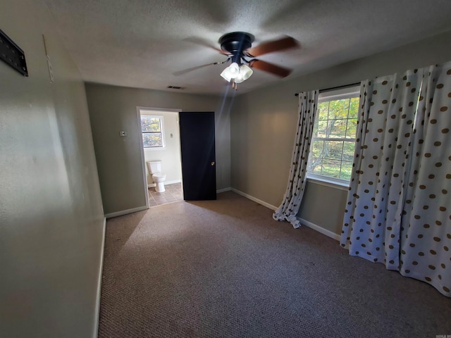 carpeted spare room featuring a healthy amount of sunlight and a textured ceiling