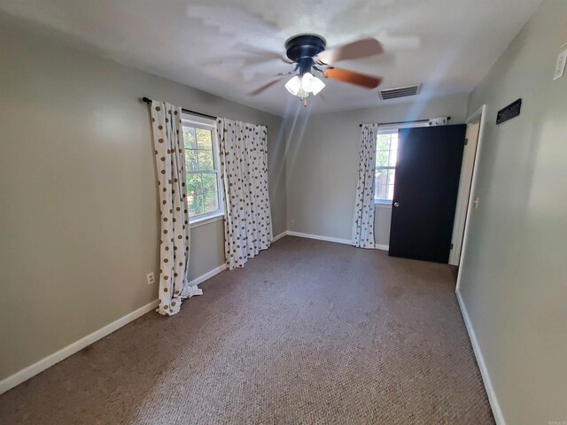 unfurnished room featuring ceiling fan and dark carpet