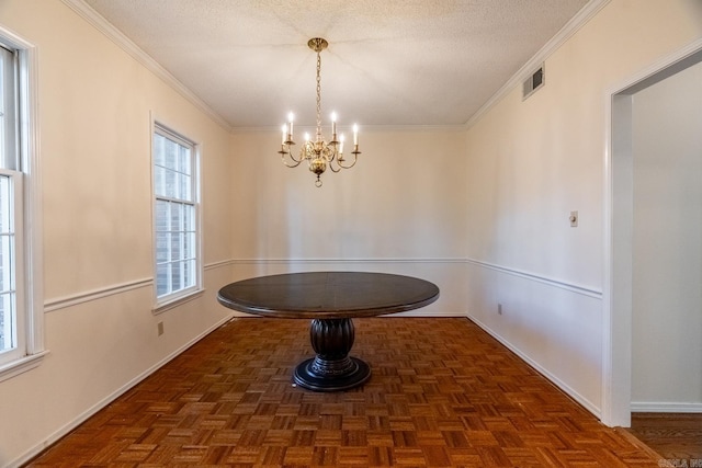 unfurnished dining area with dark parquet flooring, a chandelier, a textured ceiling, and ornamental molding