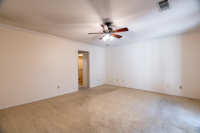 carpeted spare room featuring crown molding, ceiling fan, and a textured ceiling