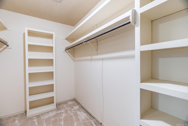 walk in closet featuring light carpet