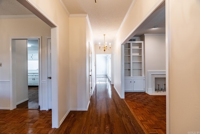 hallway featuring crown molding, a textured ceiling, and a chandelier