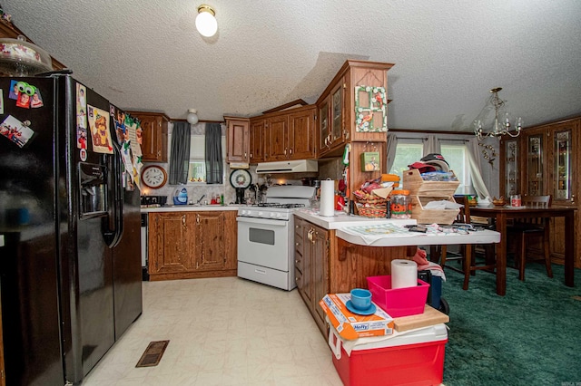 kitchen featuring vaulted ceiling, a textured ceiling, black fridge with ice dispenser, white range with gas stovetop, and a chandelier