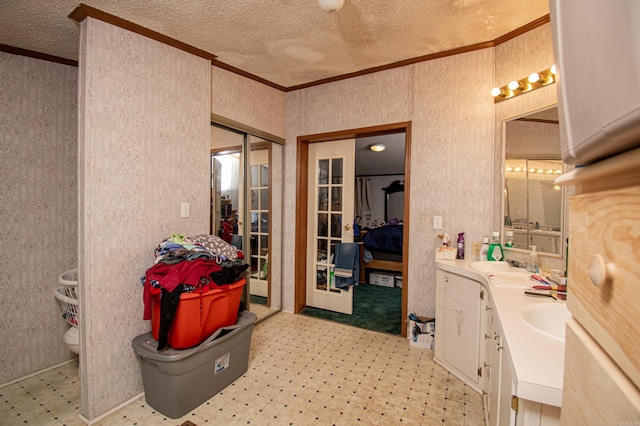 bathroom with a textured ceiling, vanity, toilet, and crown molding