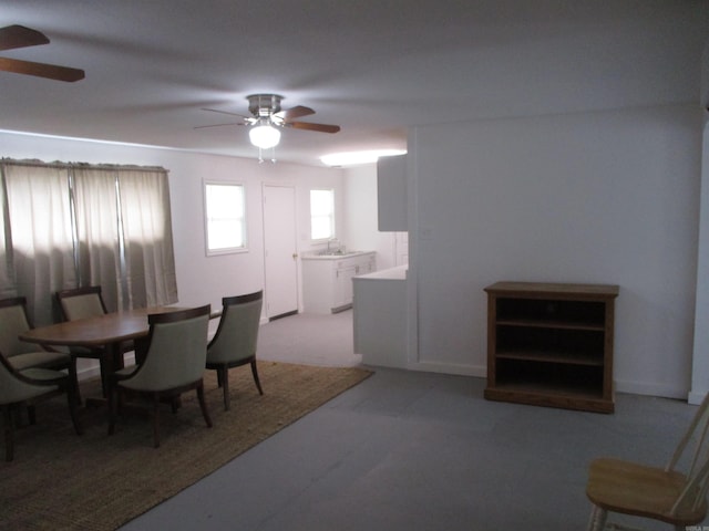 dining space with ceiling fan and light colored carpet