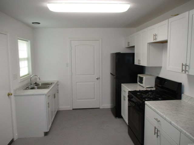 kitchen featuring gas stove, white cabinetry, and sink