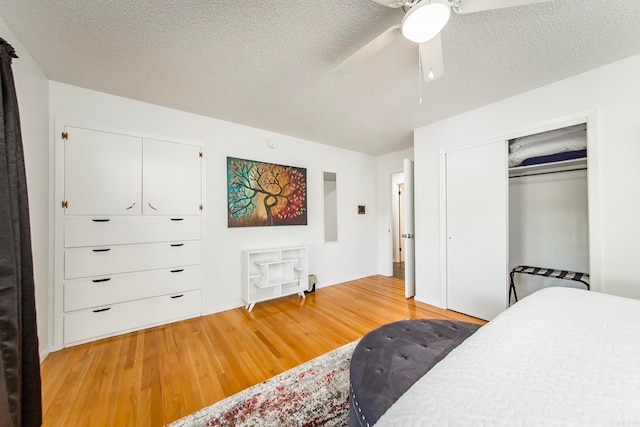 bedroom featuring a textured ceiling, light hardwood / wood-style flooring, a closet, and ceiling fan