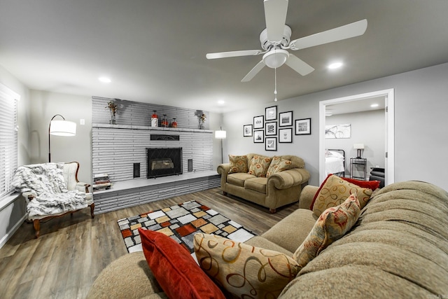 living room with dark hardwood / wood-style flooring, a fireplace, and ceiling fan