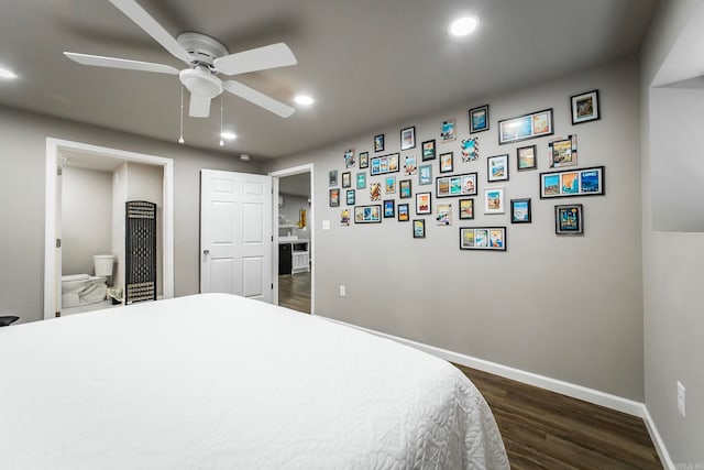 bedroom featuring dark hardwood / wood-style flooring, ensuite bath, and ceiling fan