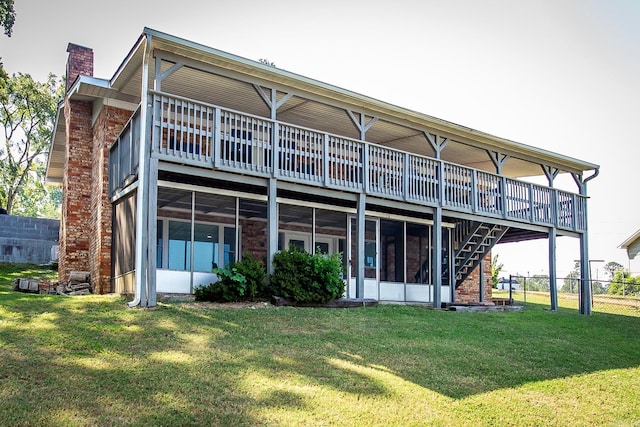 back of house with a yard, a sunroom, and a deck