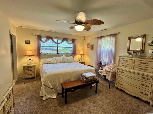 carpeted bedroom with multiple windows and ceiling fan