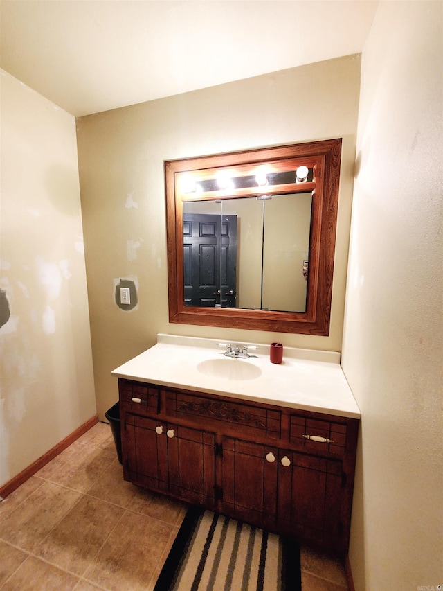 bathroom with tile patterned flooring, vanity, and baseboards