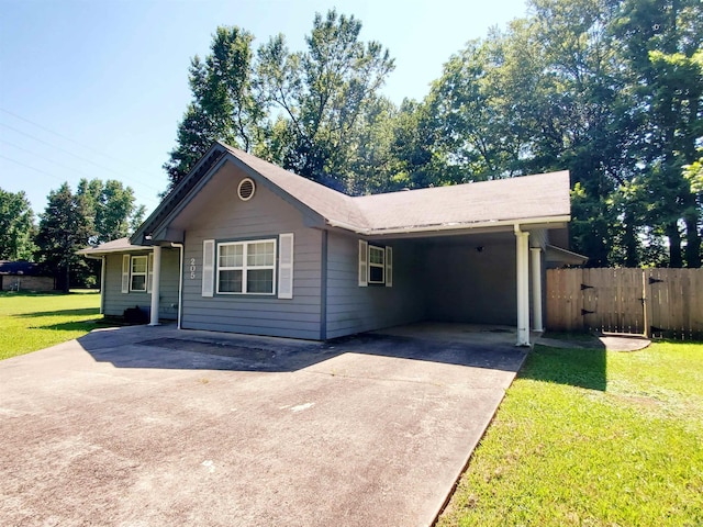 single story home with an attached carport, fence, concrete driveway, a gate, and a front lawn