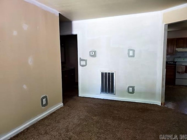 interior space with baseboards, visible vents, and dark colored carpet