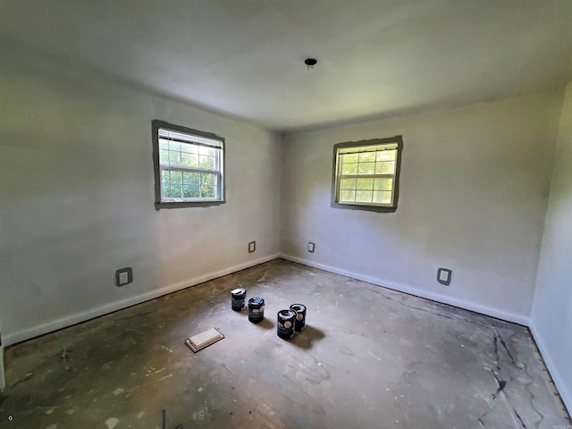 spare room with baseboards and a wealth of natural light