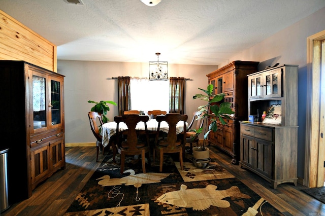 dining area featuring an inviting chandelier, dark wood-style floors, and a textured ceiling