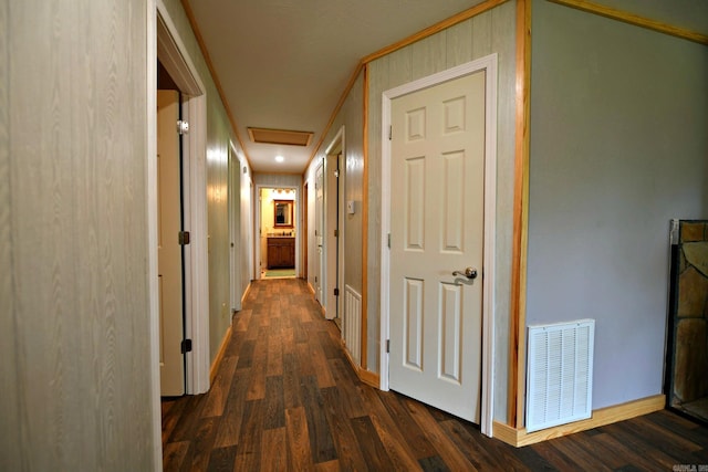 hall with attic access, baseboards, visible vents, and dark wood-style flooring