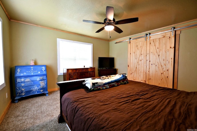 carpeted bedroom with a ceiling fan, baseboards, ornamental molding, a textured ceiling, and a barn door