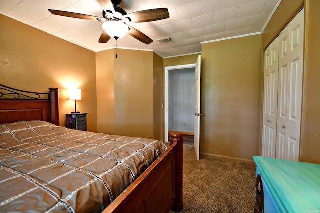 carpeted bedroom featuring crown molding, visible vents, and a closet