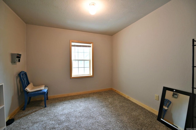 unfurnished room with baseboards, carpet floors, and a textured ceiling