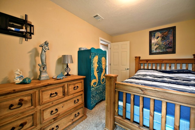 carpeted bedroom featuring visible vents and a textured ceiling