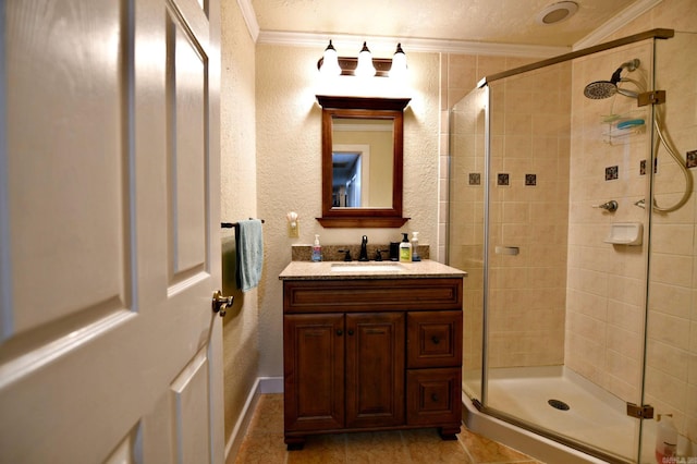 full bathroom with vanity, crown molding, a textured wall, and a shower stall