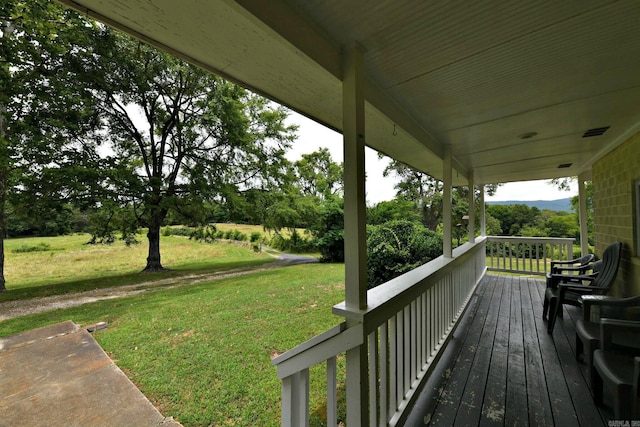 deck with covered porch and a yard