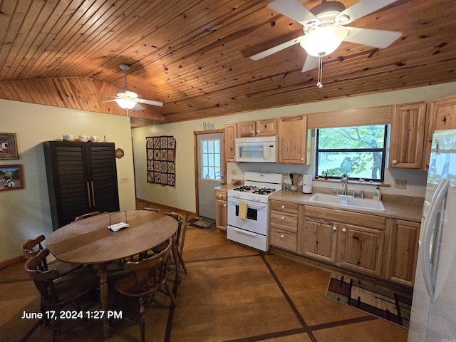 kitchen featuring sink, white appliances, vaulted ceiling, and a healthy amount of sunlight